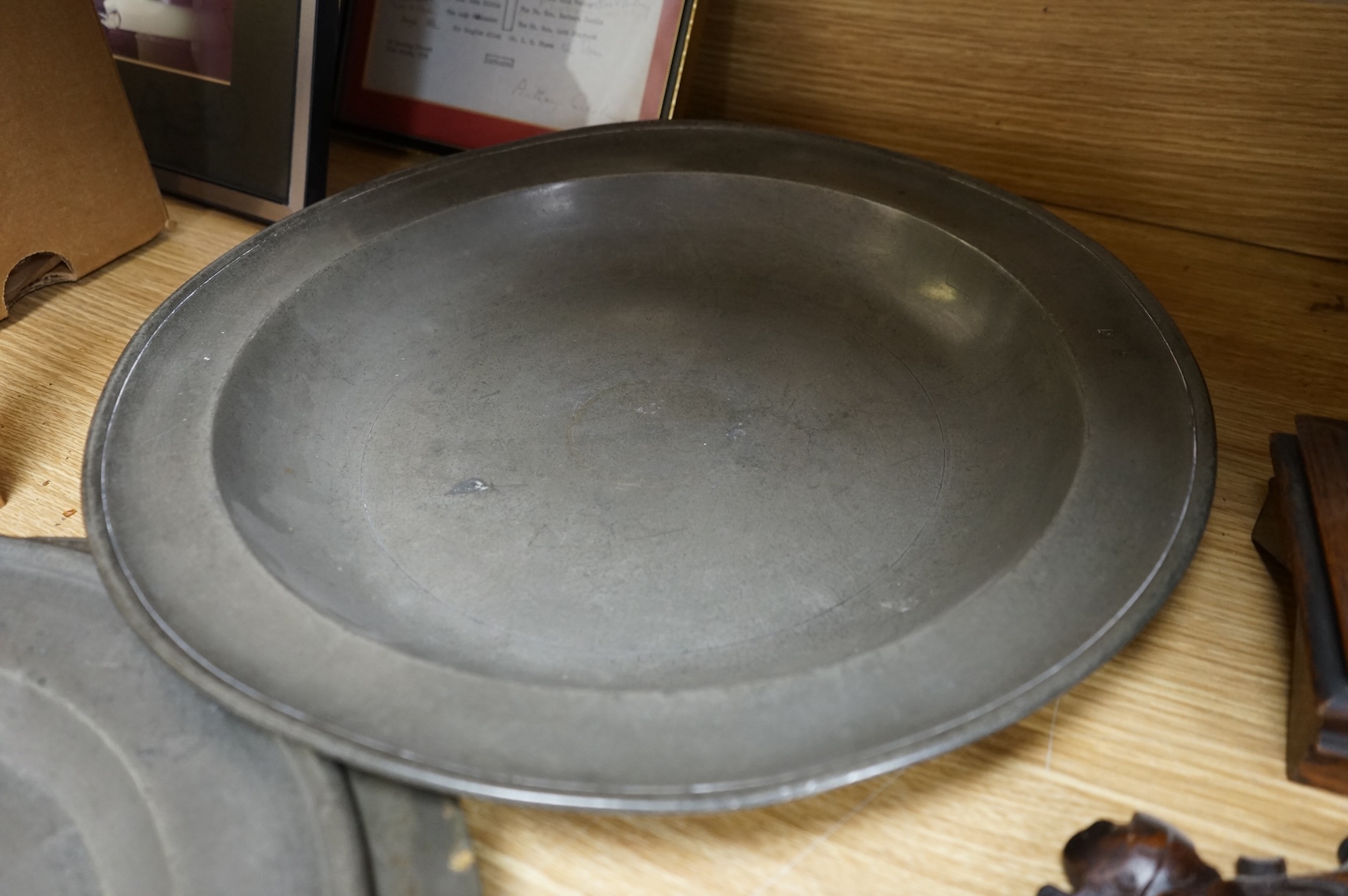Three Pewter chargers, a large dish and a plate, c.1800, largest dish 42cm diameter (5)